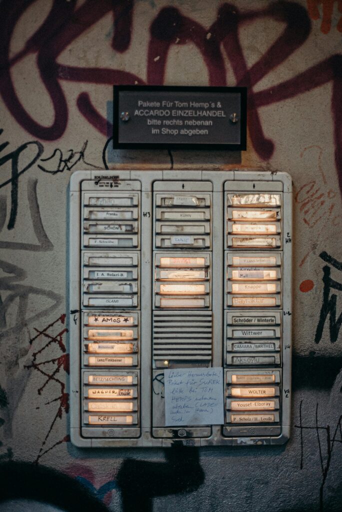 Close-up of a residential doorbell panel against a graffiti-covered wall, depicting urban lifestyle.
